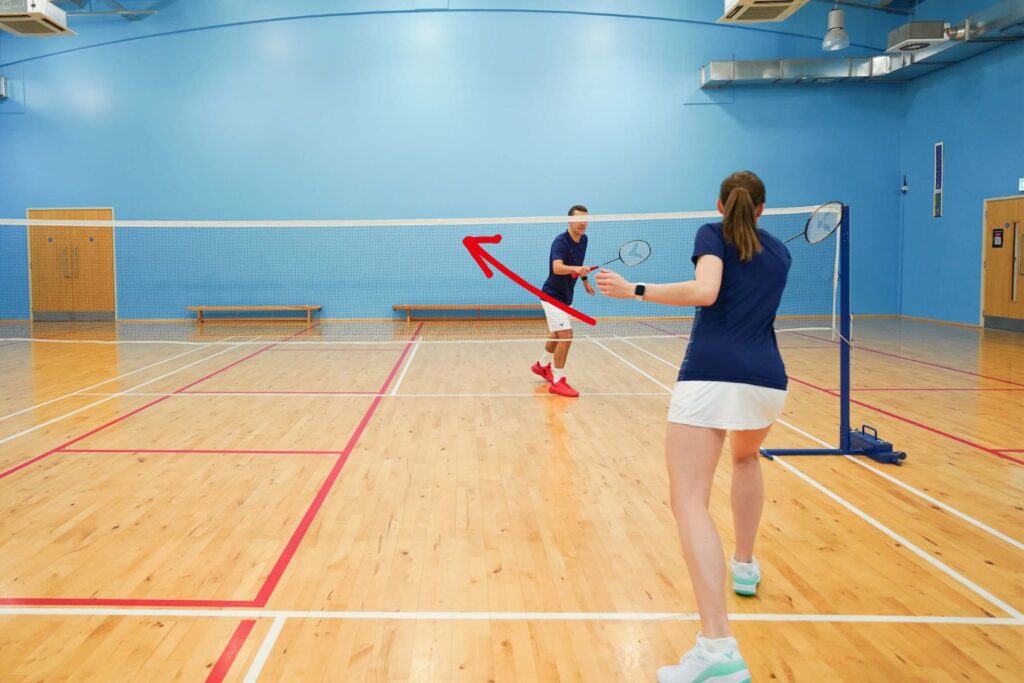 half turn net shot to the middle in badminton